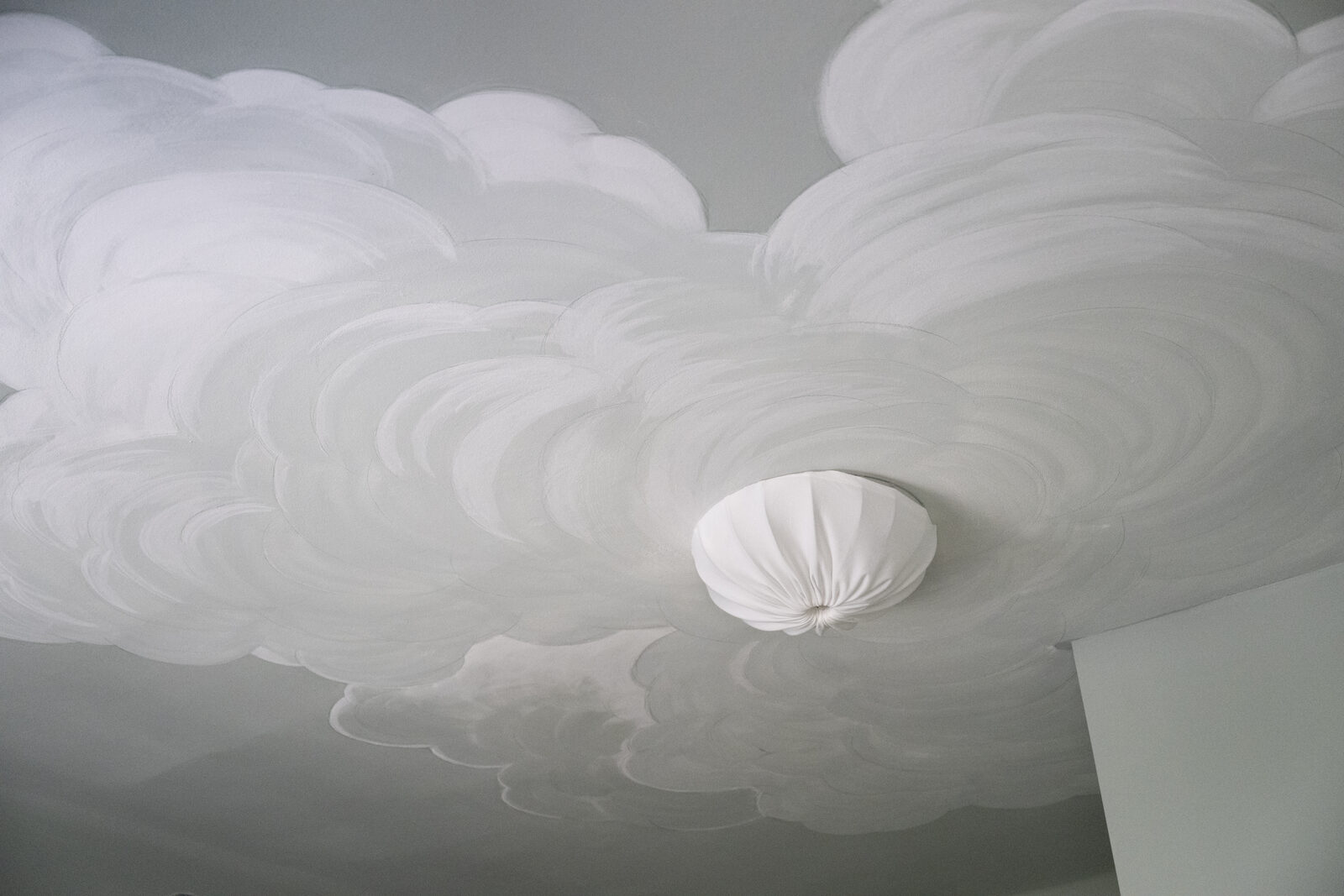 Handgemalte Wolkendecke in warm gebrochenem Grau mit Stofflampe